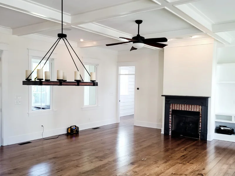Dining room with white walls, ceiling fans and wood flooring