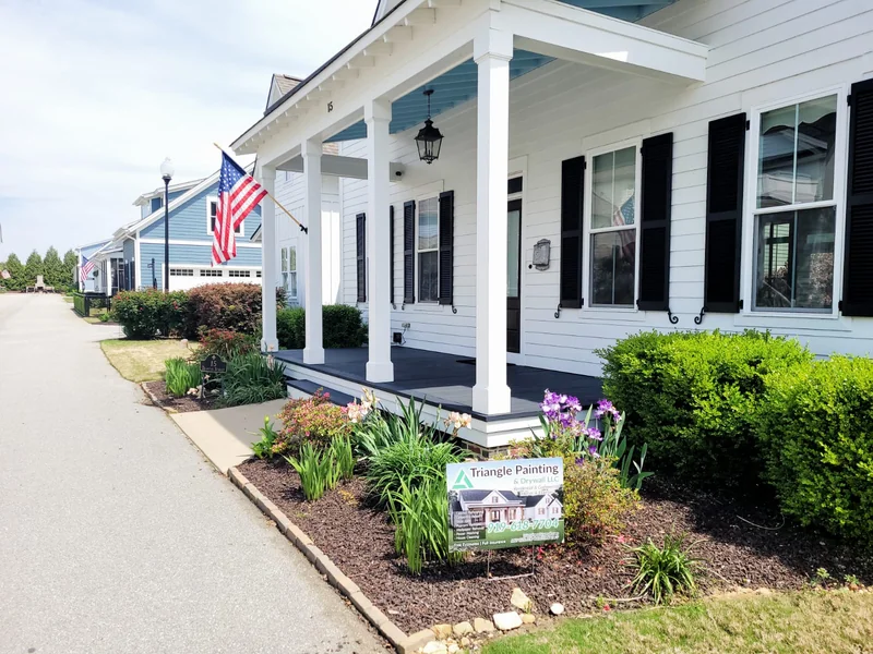 Front porch with white columns and dark window shutters