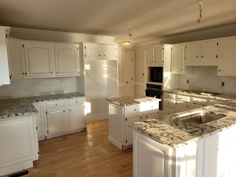 Kitchen with white cabinets and patterned countertops